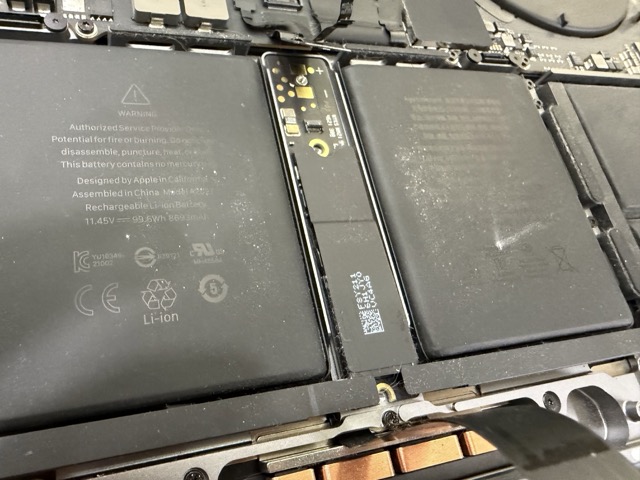 台中MacBook Pro M1電池更換維修，技師正在拆除A2485機身內原有電池