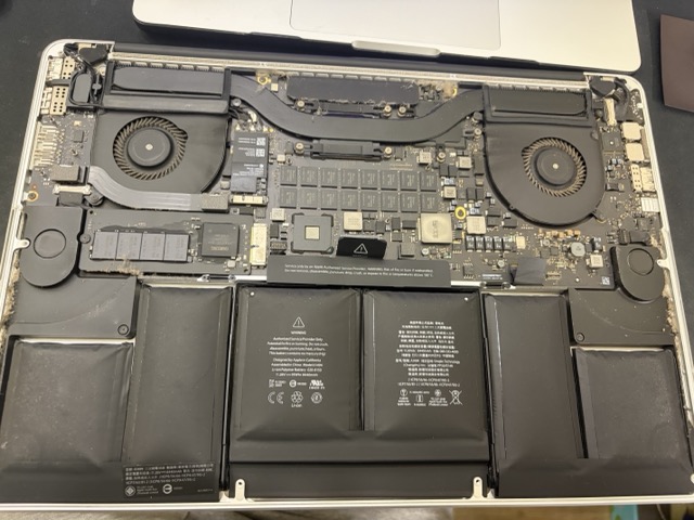 MacBook Pro 15 吋電池更換維修,拆開底殼發現原有電池膨脹及內部積塵
