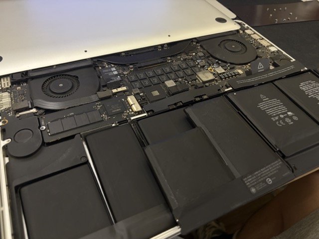 MacBook Pro 音頻 IC 故障維修 MacBook Pro 15 吋更換新電池後的內部對比照片,散熱風扇與機身灰塵已清潔